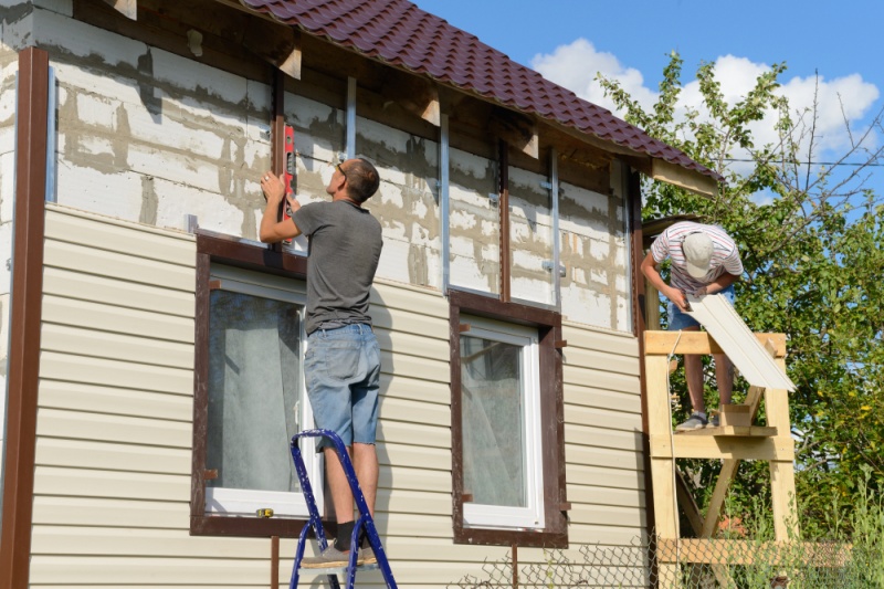 Two men finishing a siding project